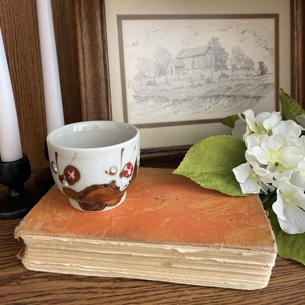 Old book with tea up, flowers, painting of scenery and white candles