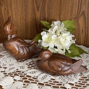 Brown duck figurines with white flower on lace